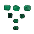 Six green faceted gemstones in varying sizes arranged on a plain white background.