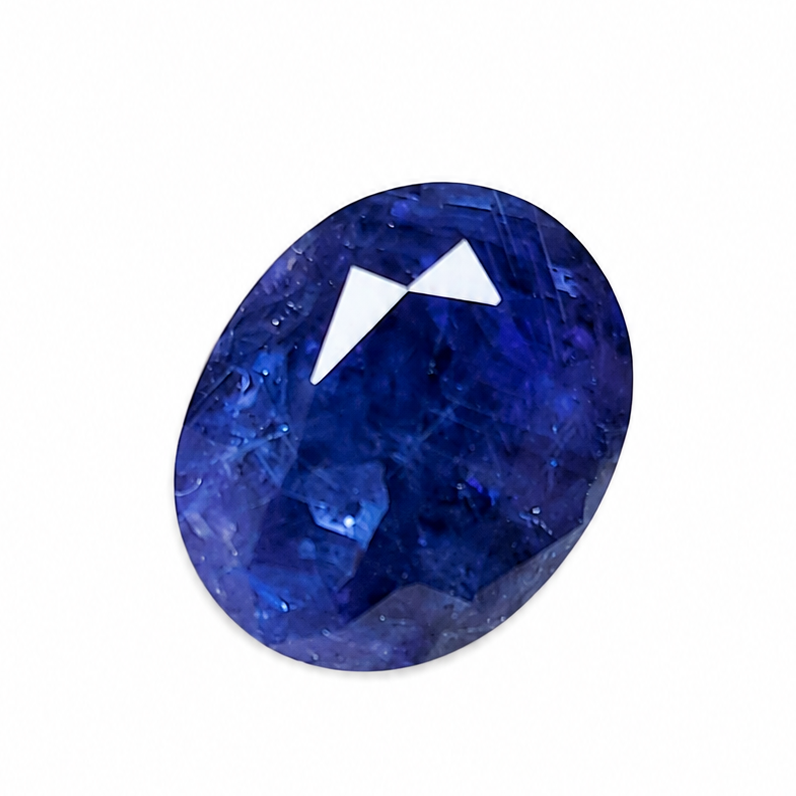 A single oval-cut deep blue gemstone with a faceted triangular cut on a plain white background.
