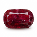 A cushion-cut, faceted ruby gemstone with deep red coloration and natural inclusions, displayed on a clean white background.