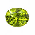 An oval-cut green gemstone with faceted cuts, isolated on a solid white background.