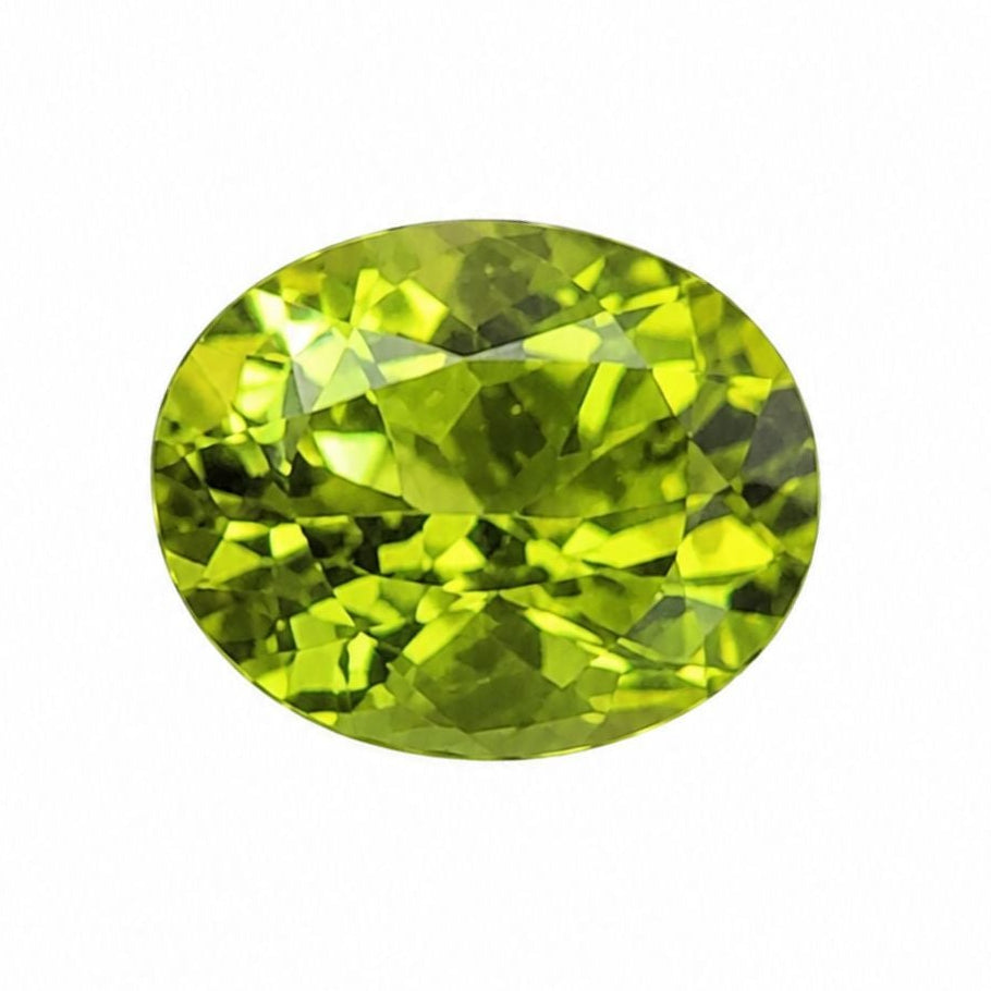 An oval-cut green gemstone with faceted cuts, isolated on a solid white background.