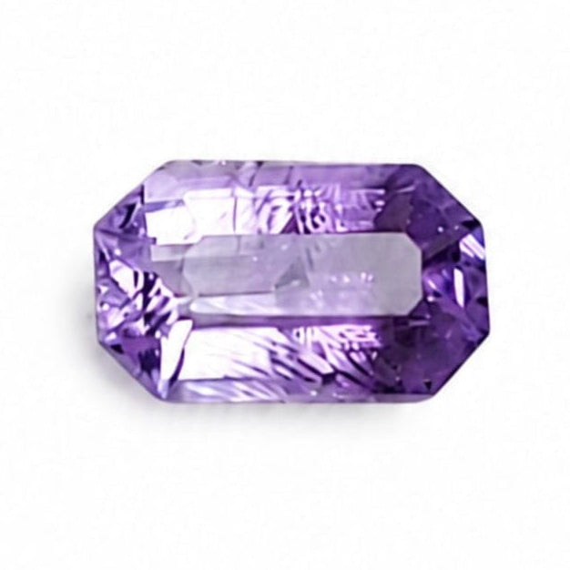 A single rectangular emerald-cut purple gemstone with a central channel cutout, displayed on a solid white background.