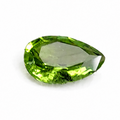 A single faceted pear-shaped green gemstone, likely a peridot, shown on a plain white background.