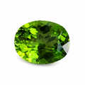 An oval-cut green gemstone with faceted facets, shown on a plain white background.