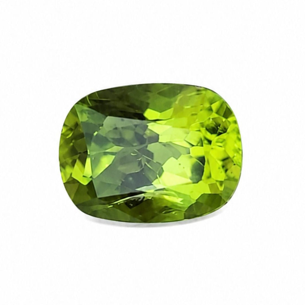 A cushion-cut green gemstone with a faceted surface, displayed on a clean white background.