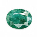 A faceted oval-cut green emerald gemstone centered on a plain white background.